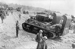 Sherman tank and troops on the beach at Tinian island, 1944